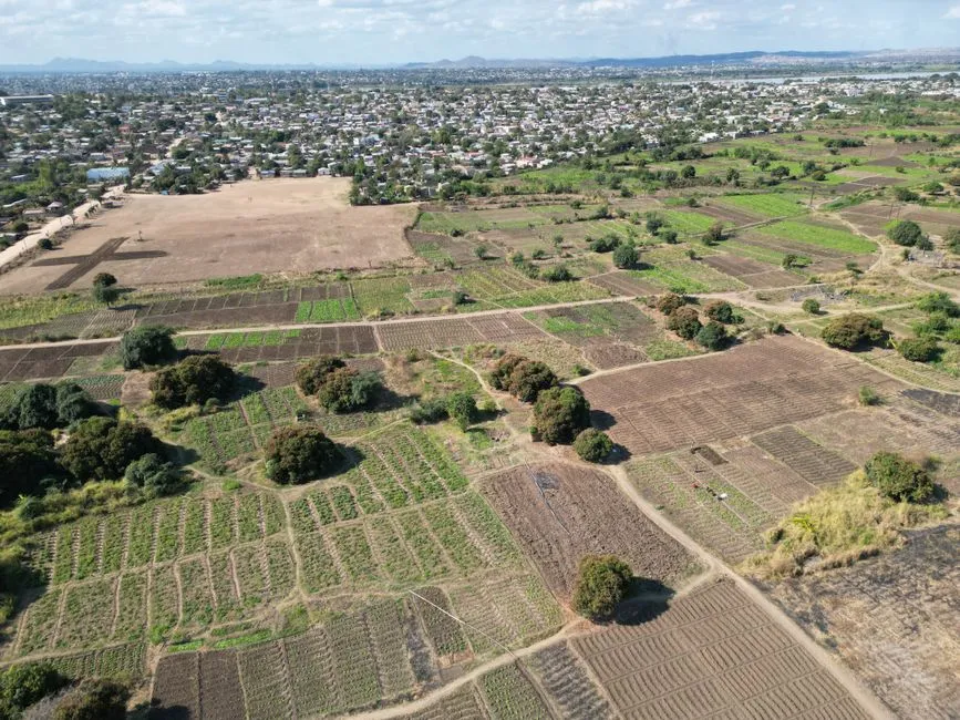 Vue aérienne expansive mettant en valeur des champs agricoles et un paysage rural près de Lilongwe, Malawi.