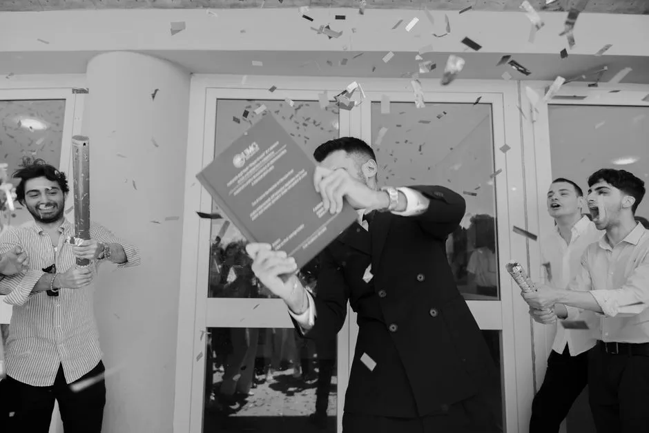 Joyeuse célébration de remise des diplômes avec des confettis et des diplômés heureux en tenue élégante.
