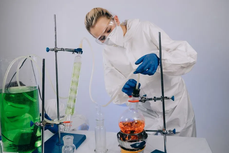 Un scientifique effectue une expérience chimique dans un laboratoire en portant un équipement de protection complète, illustrant la science moderne.