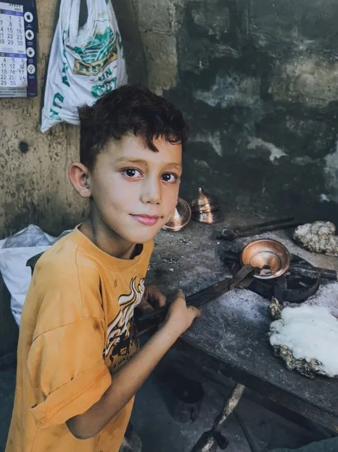 Enfant avec des outils dans un atelier artisanal apprenant des compétences en métallurgie.