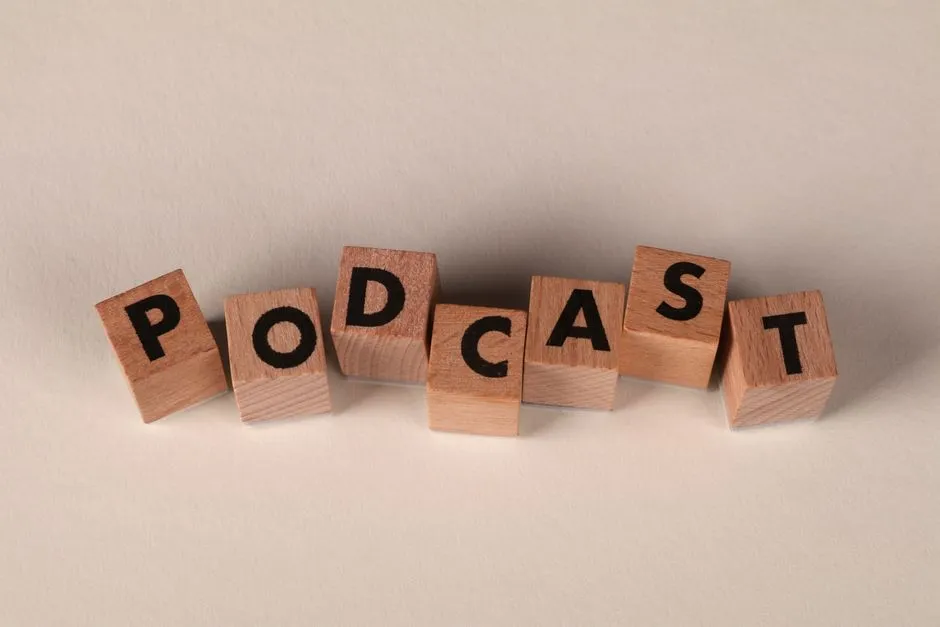 Blocs de bois portant l'inscription « PODCAST » sur un fond neutre, symbolisant la création de contenu audio.