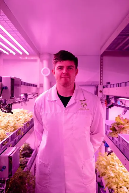 Portrait d'un scientifique travaillant dans un laboratoire de culture verticale en intérieur axé sur l'agriculture durable.